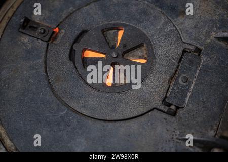 Traditional cast stove detail. Old metal and traditional cast iron hot plate of wood burning stove Stock Photo