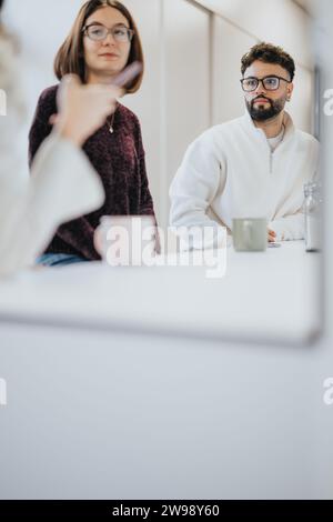 Colleagues in a modern kitchen discussing projects over coffee. A positive atmosphere for a creative team, focused on business growth and success. Stock Photo