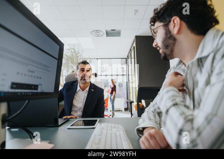 A different aged group of business professionals collaborating and discussing ideas in a corporate office, working together to achieve success. Stock Photo