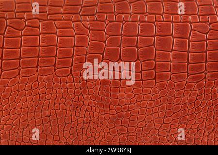 Background is made of red crocodile skin. Leather bag close-up. Stock Photo