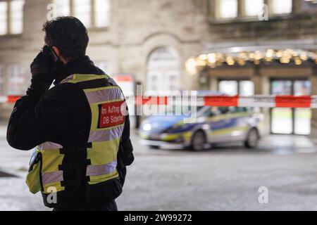 Bielefeld, Germany. 25th Dec, 2023. A railroad employee can be seen in front of the main entrance to the station. Bielefeld Central Station is searched by numerous officers. The reason for this is an anonymous attack threat. Credit: Friso Gentsch/dpa/Alamy Live News Stock Photo