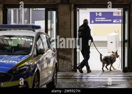 Bielefeld, Germany. 25th Dec, 2023. Police officers enter the station with a sniffer dog. Numerous officers search Bielefeld Central Station. The reason for this is an anonymous attack threat. Credit: Friso Gentsch/dpa/Alamy Live News Stock Photo