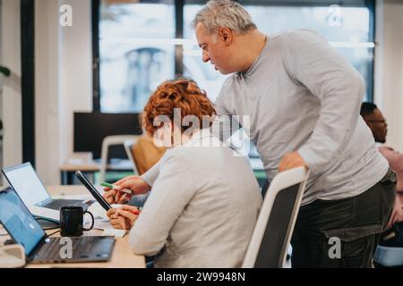 Diverse businesspeople collaborate, plan, and analyze strategies for revenue growth and customer service in a pleasant office environment. Stock Photo