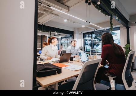 Diverse business team collaborates on marketing strategies and data analysis in modern office. Stock Photo