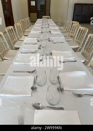 An inviting white table is beautifully set up with white place mats and matching napkins, ready for a meal Stock Photo