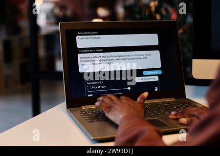 Hand of young unrecognizable African American woman typing on keyboard of laptop with assignment text on screen Stock Photo