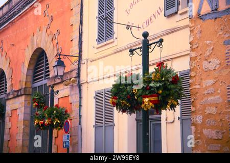 A street post with festive Christmas wreaths in front of a building in Provins, France Stock Photo