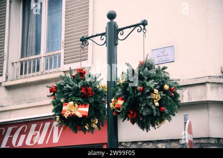 A street post with festive Christmas wreaths in front of a building in Provins, France Stock Photo