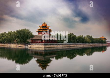 A picturesque pagoda situated in the middle of a tranquil lake surrounded by majestic mountains in the distance Stock Photo