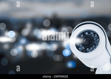 Modern security CCTV camera against blurred background, space for text Stock Photo