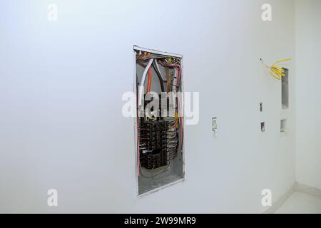 Electrical power control panel switch box is mounted to wooden frame beams on wall with circuit breaker mounted in it Stock Photo