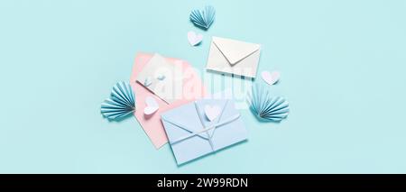 Composition with envelopes and paper hearts on light blue background, top view. Valentine's Day celebration Stock Photo