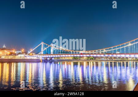 Krymsky Bridge or Crimean Bridge in Moscow at summer night. Steel suspension bridge in Moscow over the Moskva River Stock Photo