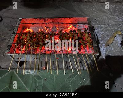 Grilling chicken satay with a charcoal fire. Stock Photo