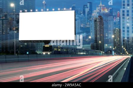Blank billboard on the highway during the twilight with city background And fireworks in the sky with clipping path on screen.- can be used for displa Stock Photo