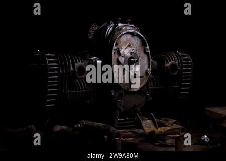 Old gasoline engine from a motorcycle on a black background. Stock Photo