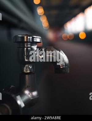 A vertical closeup of a silver water faucet Stock Photo