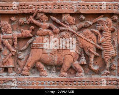 Closeup view of carved terracotta hunting scene of hunters on elephant killing tiger on ancient Govinda temple in Puthia, Rajshahi, Bangladesh Stock Photo