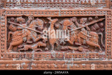 Closeup view of carved terracotta hunting scene of hunters riding horses chasing deer on ancient Govinda temple in Puthia, Rajshahi, Bangladesh Stock Photo