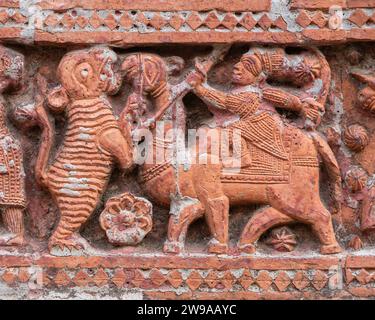 Closeup view of carved terracotta hunting scene with camel and tiger on ancient Govinda temple in Puthia religious complex, Rajshahi, Bangladesh Stock Photo