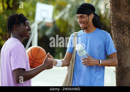 Black men having secret handshake, friends meeting to play basketball Stock Photo