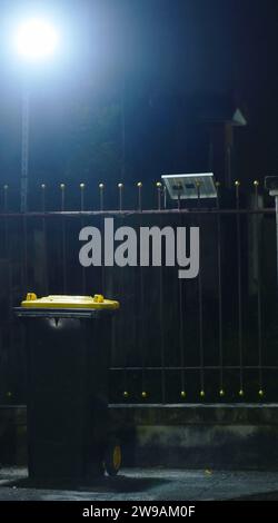 solar cell lamp in front of home spot to garbage bin in night Stock Photo