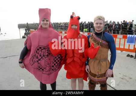 West Bay, Dorset, UK.  26th December 2023.  UK Weather:  Over one hundred and fifty swimmers in fancy dress take part in the annual West Bay Wallow Boxing Day swim at West Bay in Dorset which was supported by huge crowds on a warm overcast day.  Picture Credit: Graham Hunt/Alamy Live News Stock Photo