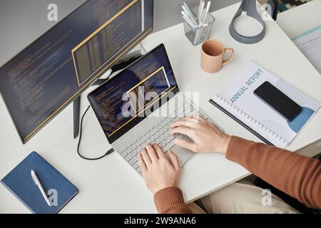 Top view closeup of unrecognizable man typing on computer keyboard and writing code at desk in office, copy space Stock Photo