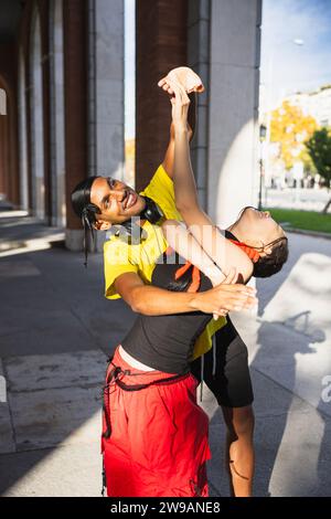 Happy smiling couple , multiracial couple dancing together an urban dance in the city. Stock Photo
