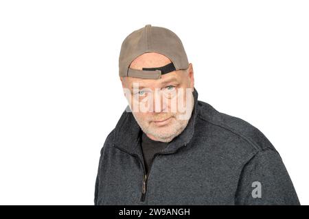 Uncertainty in the Working Class: Thoughtful Middle-Aged Man in Baseball Cap on White Background. Stock Photo