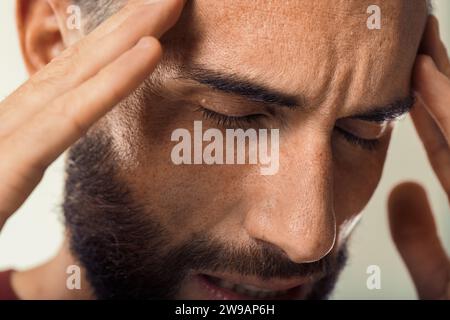 Distressed individual appears to suffer from a headache or intense concern Stock Photo