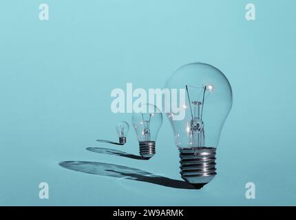 Three light bulbs on pastel blue background. Inspiration and creativity concept. Stock Photo
