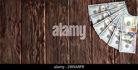 One hundred dollar bills on a wooden background of brown boards with a pronounced texture Stock Photo