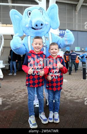 Coventry City fans pose with mascot Sky Blue Sam outside the stadium before the Sky Bet Championship match at Coventry Building Society Arena, Coventry. Picture date: Tuesday December 26, 2023. Stock Photo