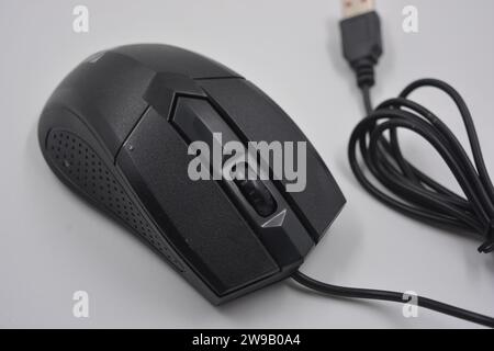 A black, stylish, sporty, computer, wired mouse with a long wire and a USB connection made of high-quality black plastic. Stock Photo