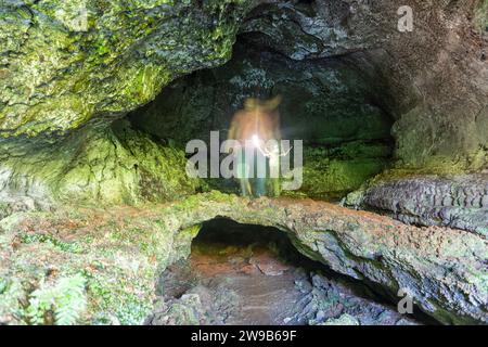 Single person in lava tunnel of Furna de Frei Matias, Pico Island, Azores, Portugal Stock Photo