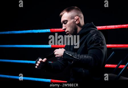 Mixed martial artist wraps bandages around his fist. Concept of mma, ufc, thai boxing, classic boxing. Mixed media Stock Photo