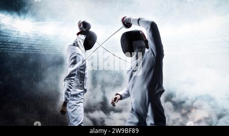 Portrait of two fencers against the backdrop of a sports arena. The concept of fencing. Duel. Mixed media Stock Photo