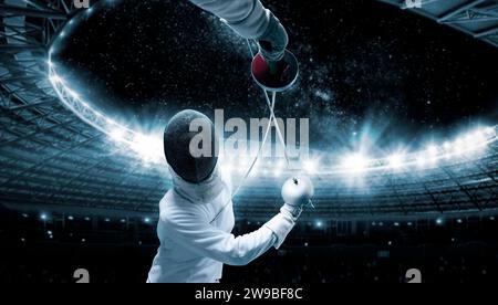 Portrait of two fencers against the backdrop of a sports arena. The concept of fencing. Duel. Mixed media Stock Photo