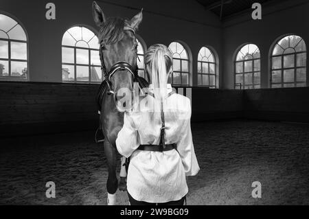 Image of a blonde woman in the form of a rider from the back. Horse racing and equestrian sport concept. Mixed media Stock Photo