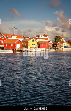Sunrise over the colourful wooden houses in the harbour of Björholmen on the island of Tjörn in the archipelago of the west coast of Sweden Stock Photo