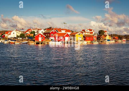 Sunrise over the colourful wooden houses in the harbour of Björholmen on the island of Tjörn in the archipelago of the west coast of Sweden Stock Photo