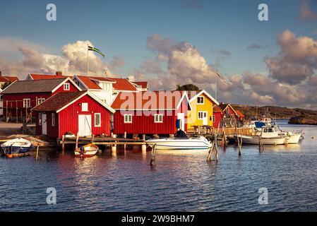 Sunrise over the colourful wooden houses in the harbour of Björholmen on the island of Tjörn in the archipelago of the west coast of Sweden Stock Photo