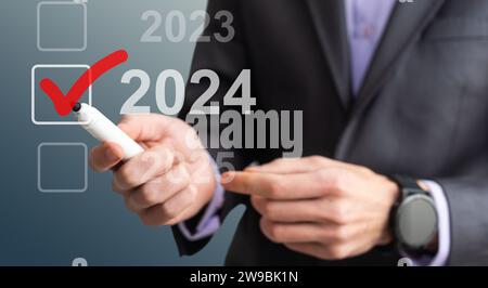 man hand touching on 2024 calender year button on digital virtual screen blur background Stock Photo