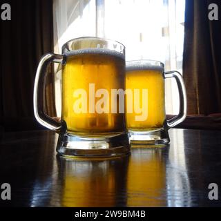 Full glasses of light beer on the wooden table at restaurant Stock Photo