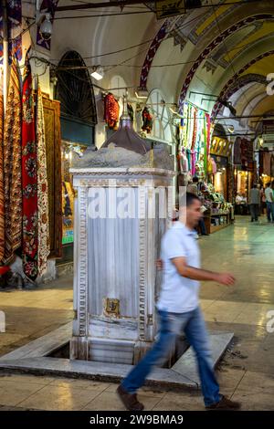 Man walking in front of ablution fountain, Grand Bazaar, Istanbul, Turkey Stock Photo