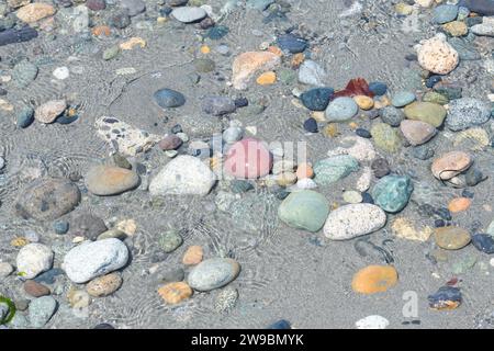 Mixture of natural stones and pebbles in shallow ocean water Stock Photo