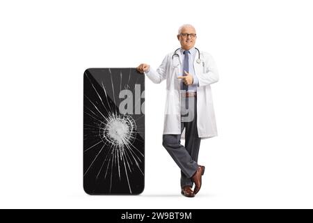 Doctor pointing at a smartphone with a cracked screen  isolated on white background Stock Photo