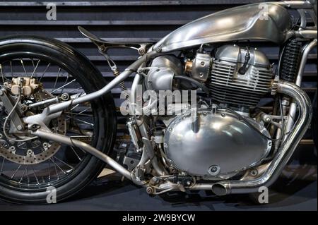 Side view of classic vintage old style chopper with shiny metal body parked on pavement Stock Photo