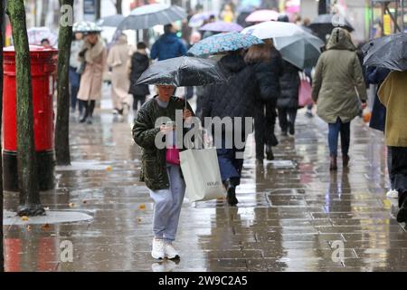 London, UK. 19th Dec, 2023. Shoppers shelter from rain under umbrellas on Oxford Street in central London. (Photo by Steve Taylor/SOPA Images/Sipa USA) Credit: Sipa USA/Alamy Live News Stock Photo